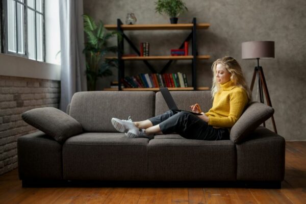 Studentin sitzt auf Sofa