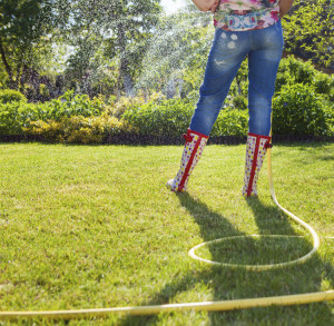 Frau bewässert ihren Garten