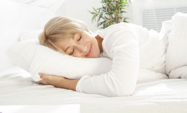 Frau schläft im Bett und ist glücklich