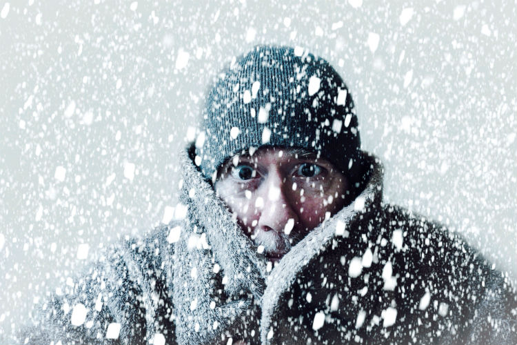 Mann steht im Schnee und freiert