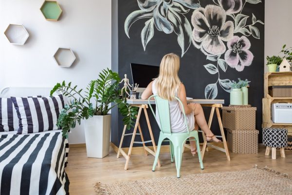 Blonde Frau am Schreibtisch neben ihr das Bett