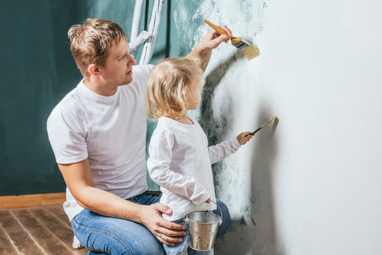 Vater und Tochter streichen mit Öko Farben Wand