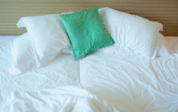 Ein ungemachtes Bett mit Kissen und Decken