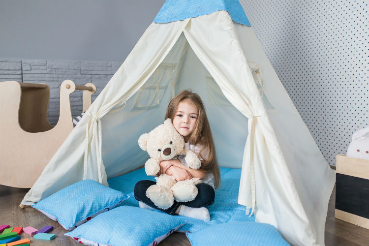 Wohlfühl-Kinderzimmer - Mädchen sitzt in Spielezelt im Kinderzimmer