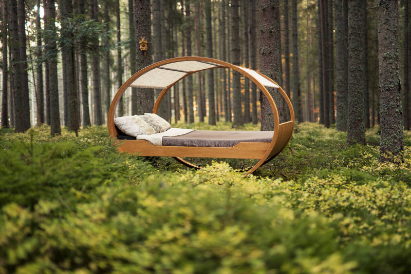 Ein Bett steht in einem Wald