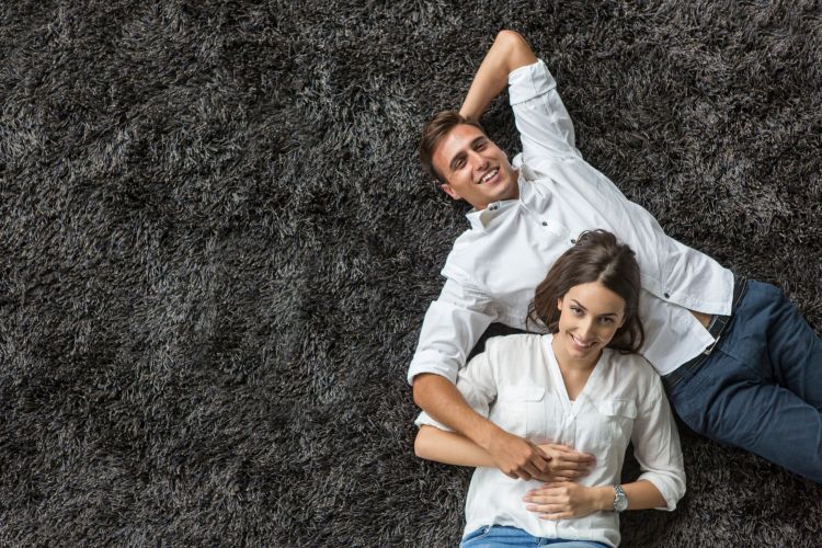 Mann & Frau liegen auf dem Teppich