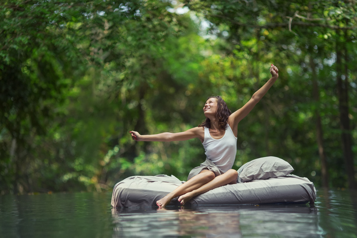 Frau erwacht auf Bett im Wasser