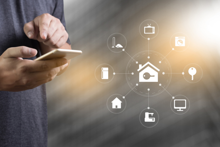 Mann steuert von seinem Handy sein Smart Home
