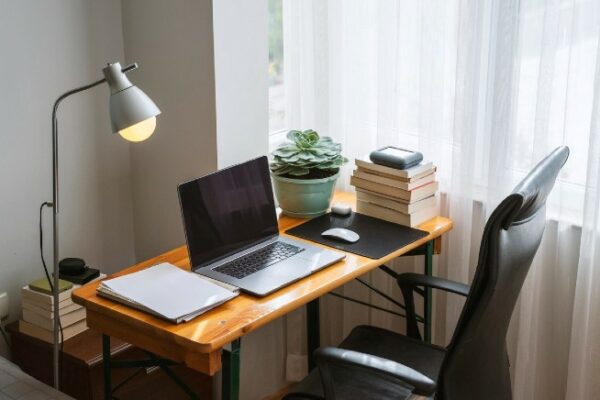 Schreibtisch mit Laptop und Lampe