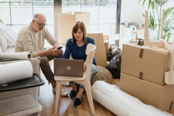 Ein Ehepaar sitzen vor Umzugskartons in ihrer neuen Wohnung